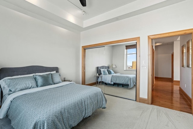 bedroom with ceiling fan, rail lighting, a closet, and carpet floors