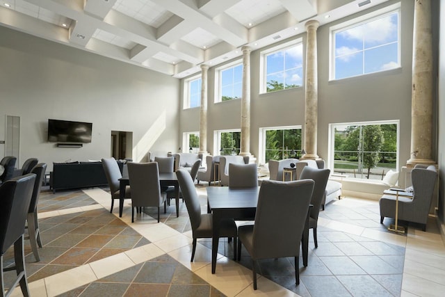 tiled dining area with a towering ceiling, beamed ceiling, and decorative columns