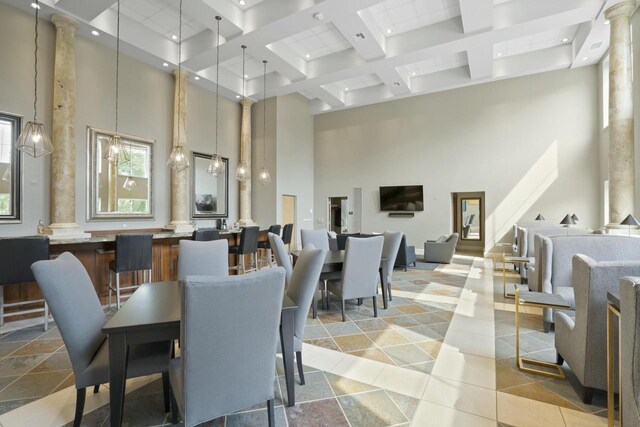 dining area with a towering ceiling and ornate columns