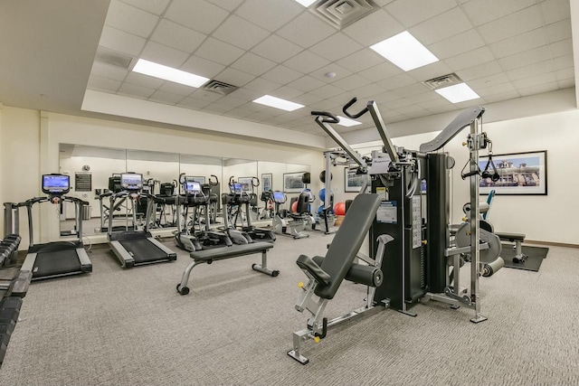 exercise room featuring carpet floors and a paneled ceiling