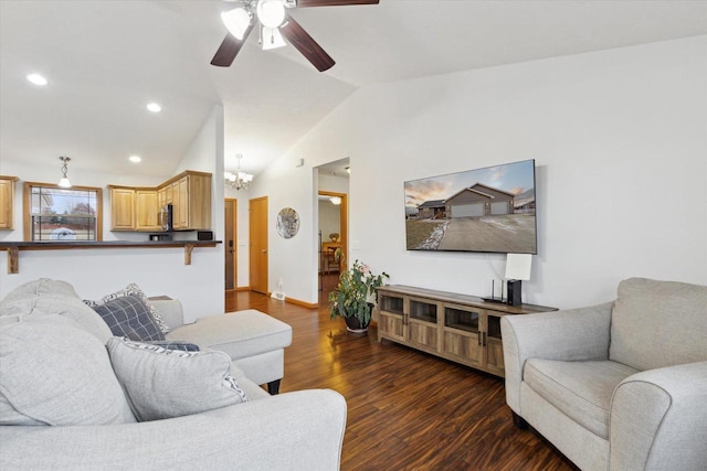 living room with ceiling fan with notable chandelier, dark hardwood / wood-style floors, and vaulted ceiling