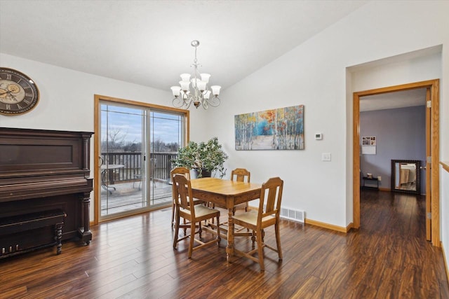 dining area featuring vaulted ceiling, dark hardwood / wood-style floors, and an inviting chandelier