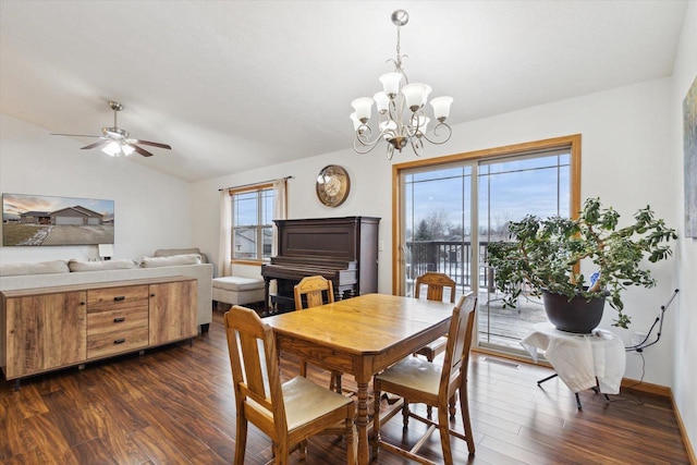 dining area featuring ceiling fan with notable chandelier, dark wood-type flooring, and vaulted ceiling