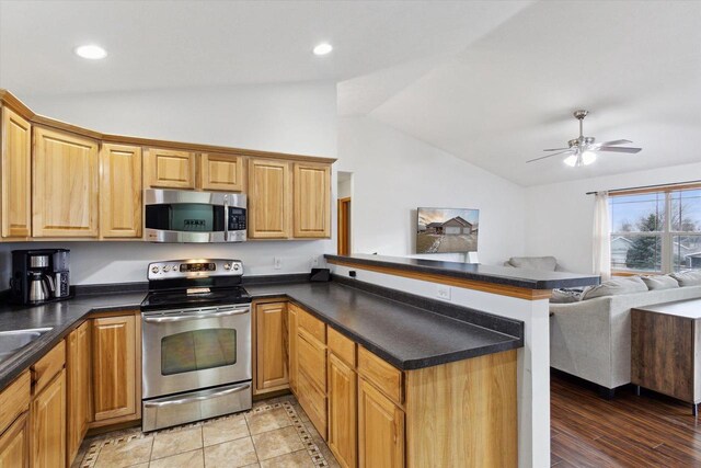 kitchen with light hardwood / wood-style floors, kitchen peninsula, ceiling fan, stainless steel appliances, and lofted ceiling