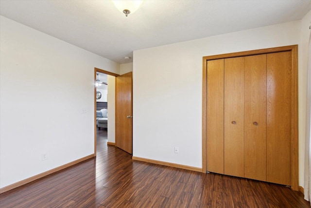 unfurnished bedroom featuring dark hardwood / wood-style floors and a closet