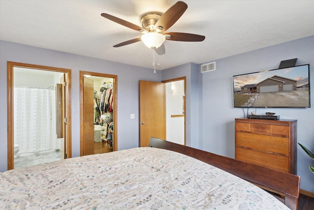 bedroom with ceiling fan, ensuite bathroom, a spacious closet, and a closet