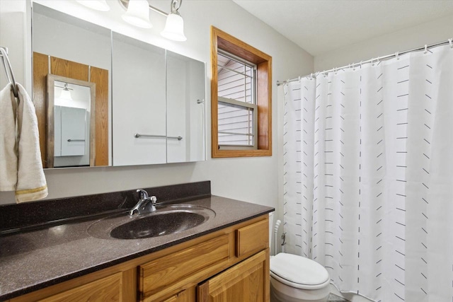 bathroom with toilet, a shower with shower curtain, and vanity