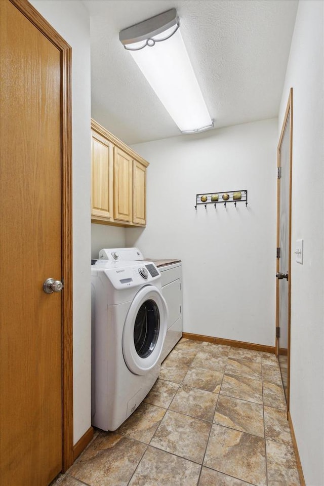 laundry area with washer and dryer, cabinets, and a textured ceiling