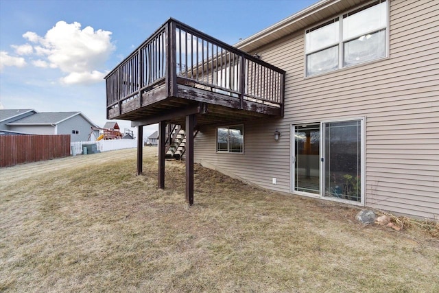 rear view of property featuring a deck and a yard