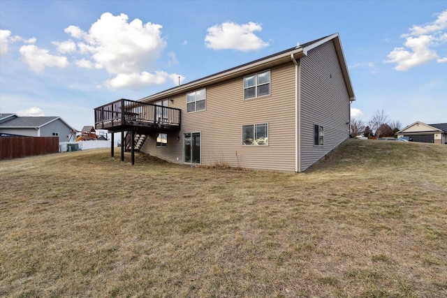 rear view of house featuring a yard and a wooden deck