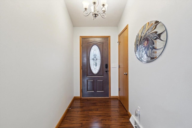 doorway with a notable chandelier and dark hardwood / wood-style flooring