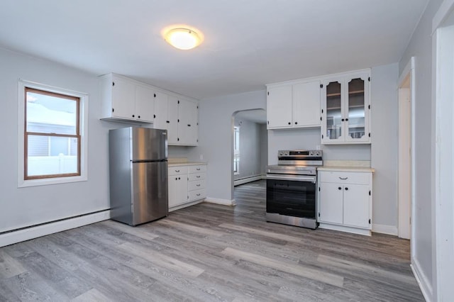 kitchen featuring baseboard heating, white cabinetry, appliances with stainless steel finishes, and light hardwood / wood-style flooring