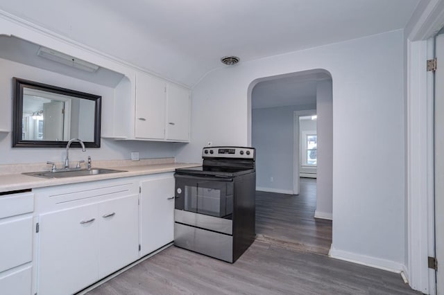 kitchen featuring white cabinetry, stainless steel electric stove, light hardwood / wood-style floors, and sink