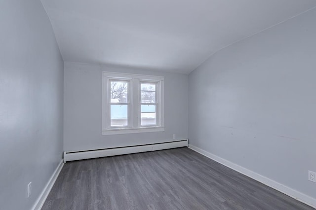 spare room with lofted ceiling, dark hardwood / wood-style floors, and a baseboard radiator