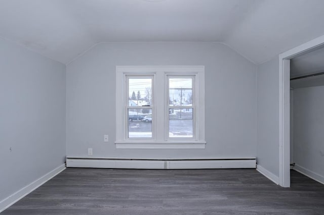 additional living space featuring lofted ceiling, baseboard heating, and dark hardwood / wood-style floors