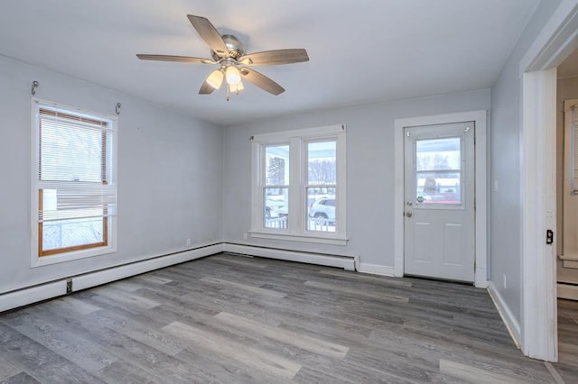 foyer entrance with ceiling fan, baseboard heating, and hardwood / wood-style floors