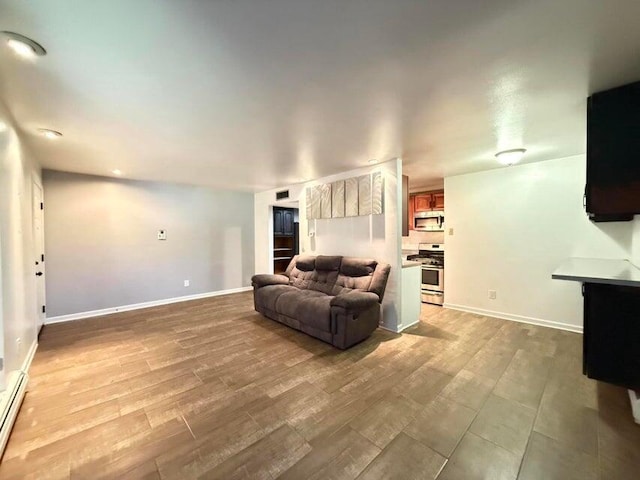 living room with baseboard heating and light hardwood / wood-style flooring