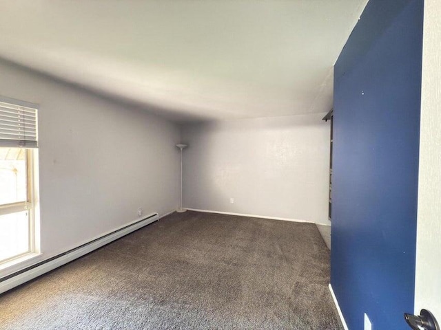 empty room with baseboard heating and dark carpet