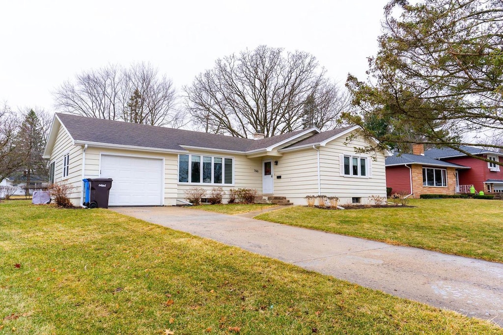 ranch-style house featuring a garage and a front lawn