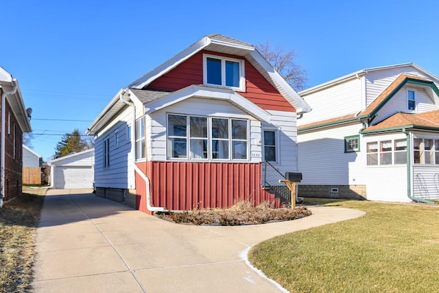 view of front of house featuring an outbuilding, a front yard, and a garage