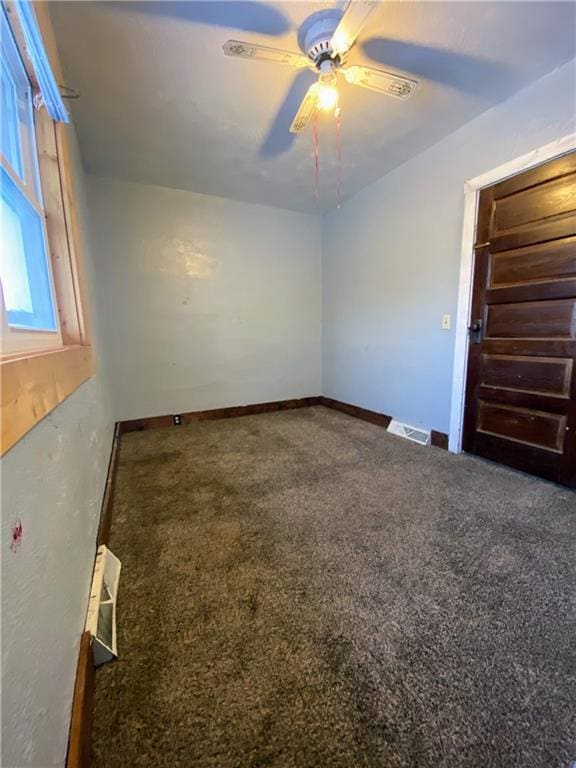 carpeted spare room featuring ceiling fan