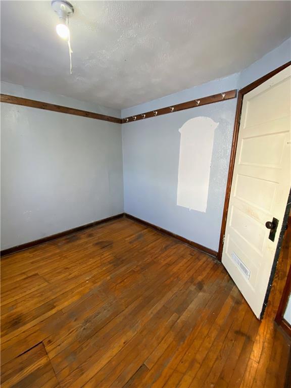 unfurnished room featuring dark wood-type flooring