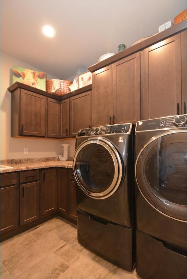 laundry room with washing machine and dryer and cabinets