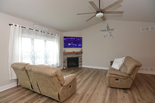 living room with ceiling fan, hardwood / wood-style floors, lofted ceiling, and a fireplace