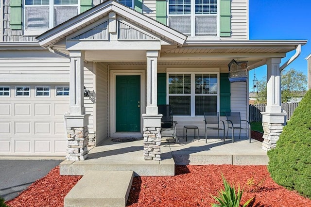 view of exterior entry with covered porch and a garage