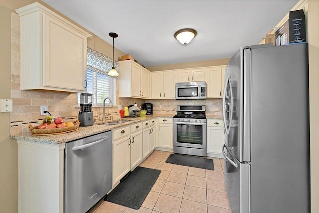 kitchen featuring sink, pendant lighting, backsplash, and stainless steel appliances