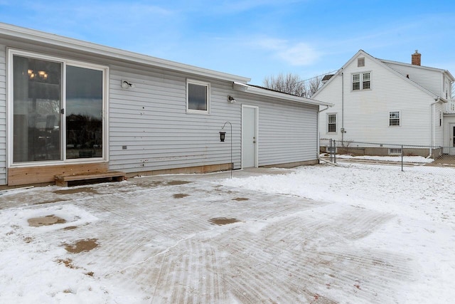 view of snow covered back of property