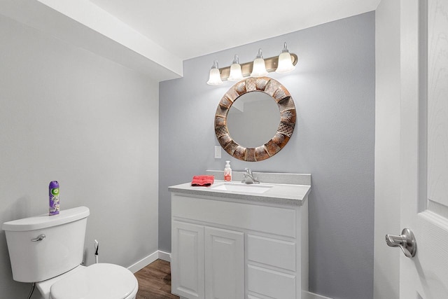 bathroom with toilet, vanity, and hardwood / wood-style flooring