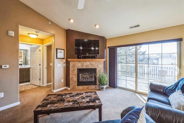 living room with lofted ceiling, light carpet, and a fireplace