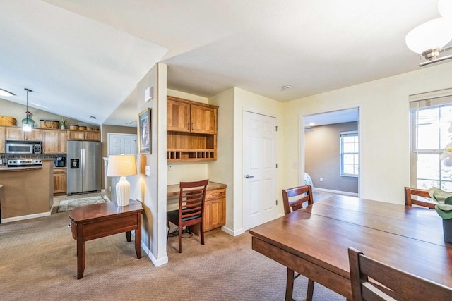 carpeted dining space featuring lofted ceiling