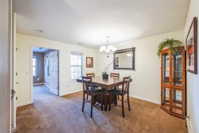 carpeted dining area featuring an inviting chandelier