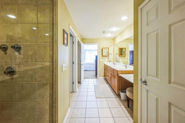 bathroom featuring vanity, tile patterned flooring, and a tile shower