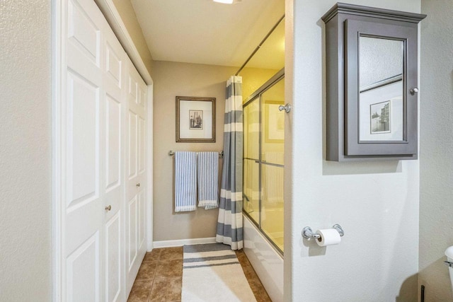 bathroom with enclosed tub / shower combo, toilet, and tile patterned flooring