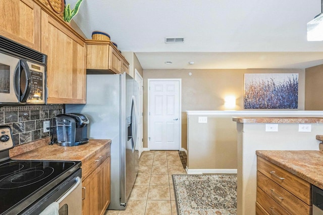 kitchen featuring light tile patterned flooring, stainless steel appliances, decorative backsplash, and light stone countertops