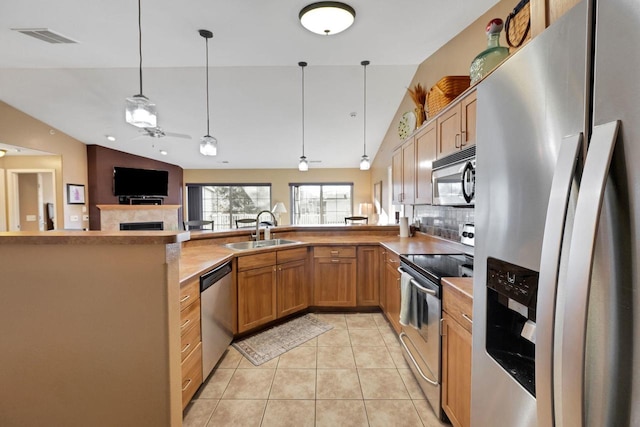 kitchen featuring stainless steel appliances, sink, backsplash, vaulted ceiling, and ceiling fan