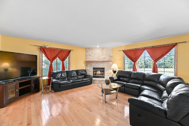 living room featuring light wood-type flooring and a fireplace