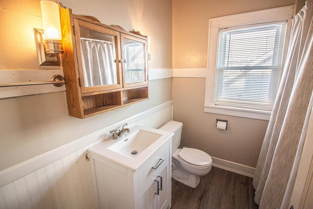 bathroom with toilet, wood-type flooring, and vanity