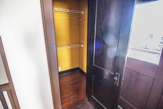 corridor with dark wood-type flooring and a wealth of natural light