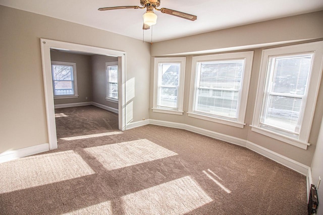 carpeted empty room featuring ceiling fan