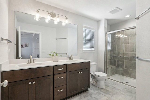 bathroom featuring toilet, vanity, and a shower with door