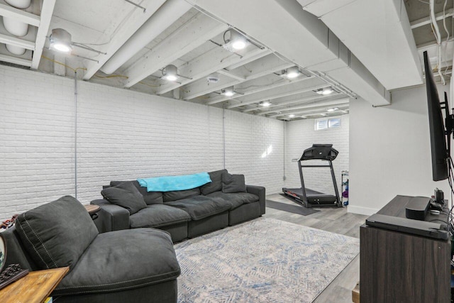 living room featuring brick wall and light hardwood / wood-style flooring