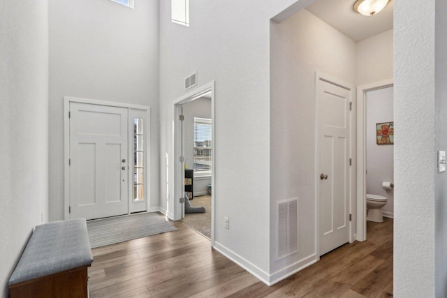 entrance foyer featuring hardwood / wood-style floors and a towering ceiling