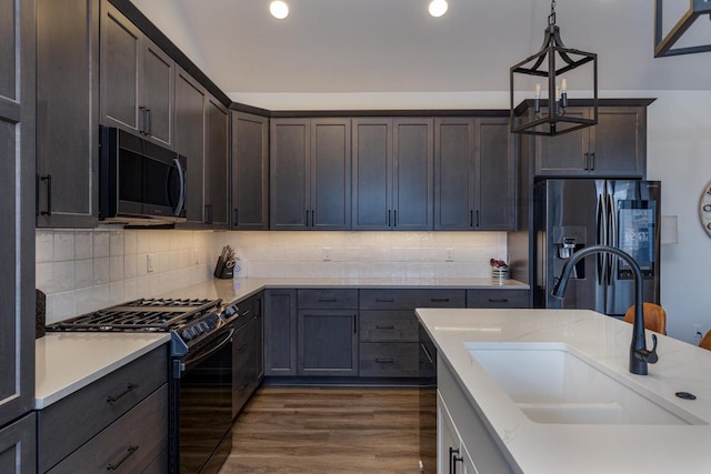 kitchen featuring dark hardwood / wood-style floors, pendant lighting, sink, dark brown cabinetry, and stainless steel appliances