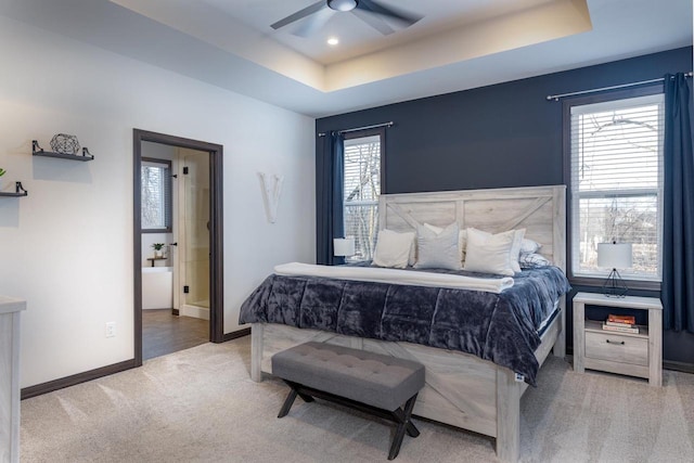 carpeted bedroom featuring ceiling fan and a raised ceiling