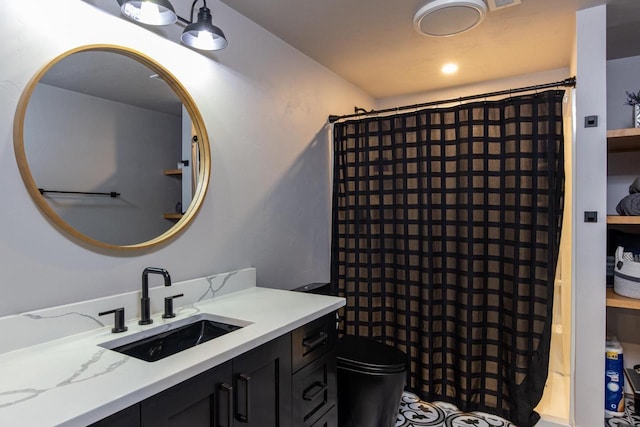 bathroom featuring toilet, vanity, and a shower with curtain