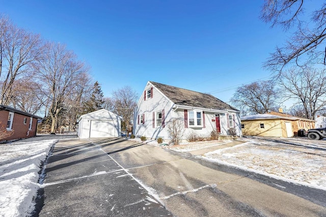 view of front of home with a garage and an outbuilding